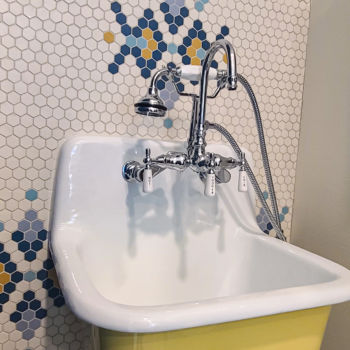 White and yellow ceramic bathroom sink with vintage look. Custom wall tiled with white, yellow, and various blue penny tile. Tile installation by GWH Flooring in Driftwood Texas.