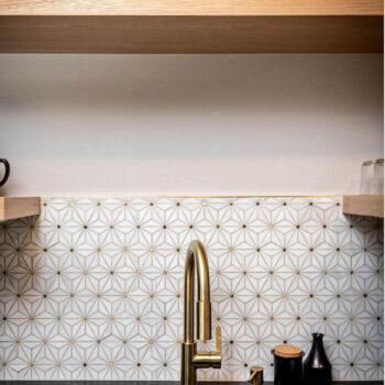 White and gold mosiac tile. Black granite countertops and pine floating shelves with gold faucet. Tile installed by GWH Flooring in San Marcos, Texas