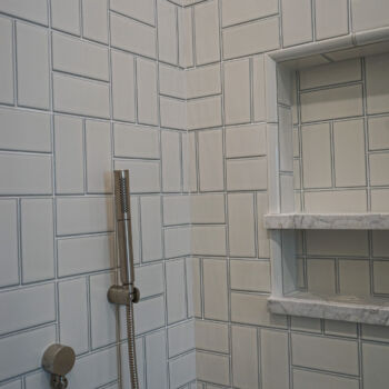 Basket weave white tile and niche in shower. Installation by GWH Flooring company