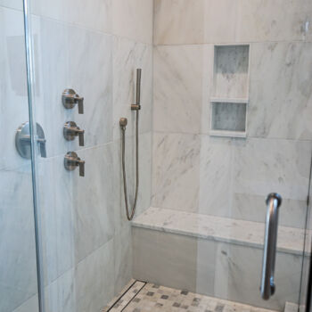 Quartz tiles in shower. Glass door, shower niche and bench. Installation by GWH Flooring in Central Texas Hill Country