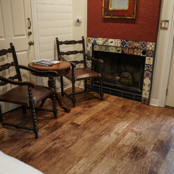 Wood floor with custom colorful spanish tiles around a fireplace. Installed by GWH Flooring store