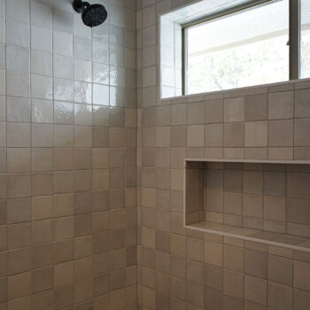 Grey shower tile with niche and window installed by GWH Flooring store in Wimberley