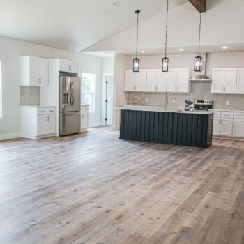 Beautiful open kitchen. LVT wood floors, grey tile backsplash, and white quartz countertops installed by GWH Flooring
