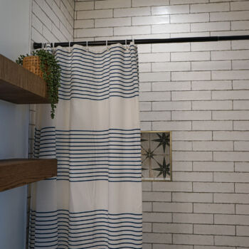 shower with white subway tiles brick layed with dark grey grout and star tiles for the niche. Tiles installed by GWH Flooring store