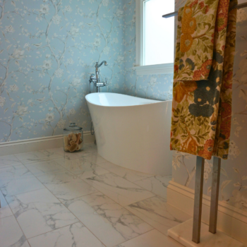 Renovated bathroom with standalone tub with large marble tiles for bathroom floor.