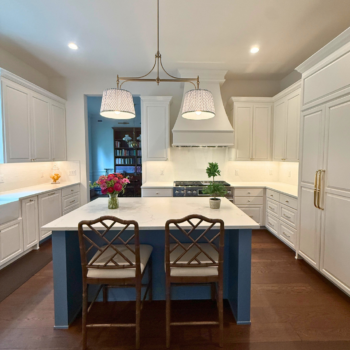 Renovated kitchen with white quartz countertops, white subway tile backsplash, and dark hard wood floors.