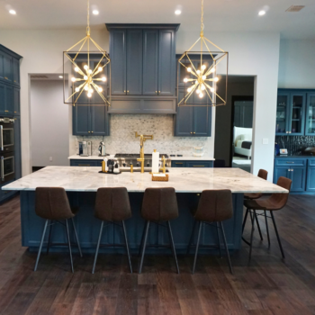 modern kitchen design with blue cabinets, marble countertop, wood floor, and mosaic backsplash