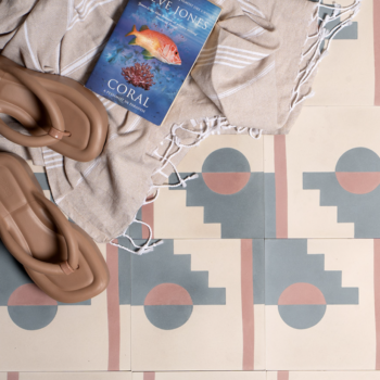 Pink and blue outdoor tiles with southwest design. Blanket with book and sandals on top. Otto tiles.